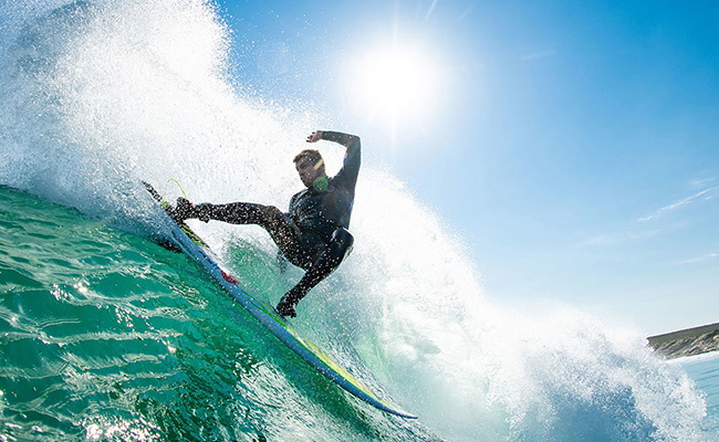 surfista comprobando el ajuste de su neopreno