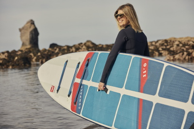 Practicante de paddle surf en aguas tranquilas con una ayuda a la flotabilidad