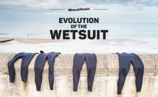Trajes de neopreno colgados en un muro junto al mar