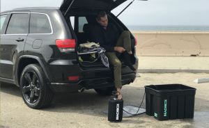 Man in his car next to a beach box shower