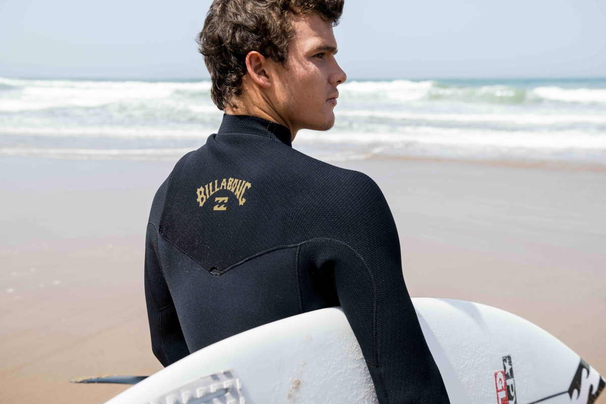 hombre en la playa con un neopreno Billabong