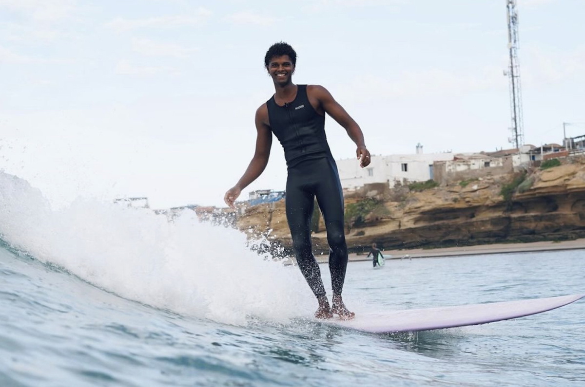Surfista con el neopreno sin mangas Nyord Solu Long Jane en la playa en verano