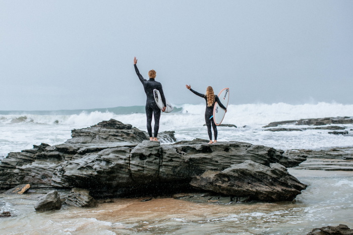 Surfista con un neopreno Rip Curl Trad entrando al agua con su tabla